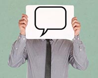Person in Business-Outfit hält ein Schild mit einer leeren Sprechblase vor dem Gesicht