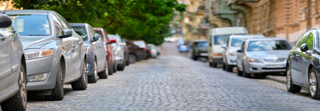 Parkende Autos links und rechts am Straßenrand in der Stadt