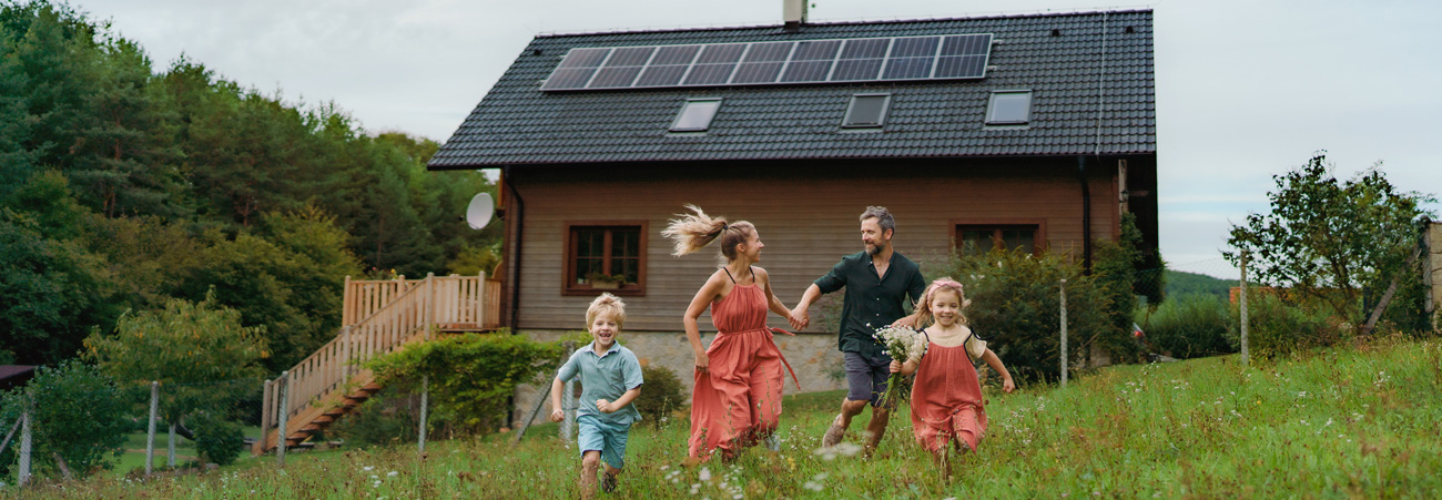 Familie auf Wiese vor ihrem Haus