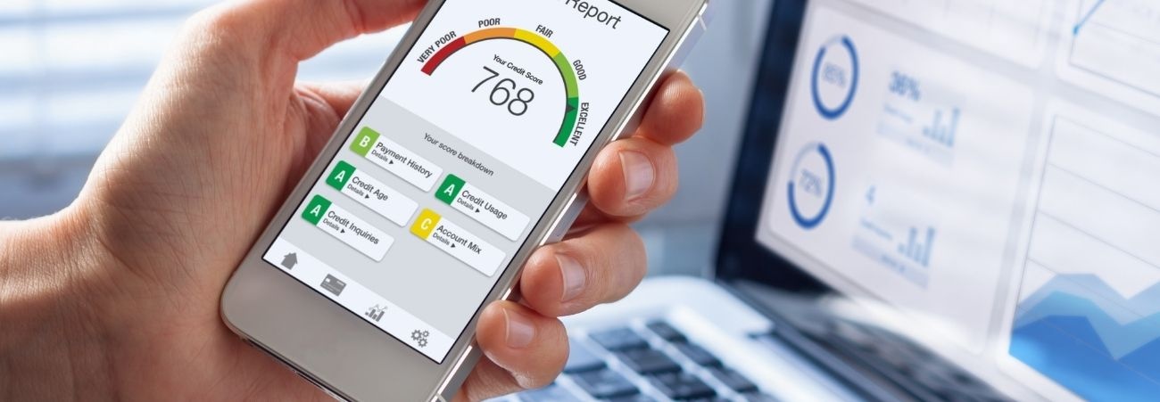 Hand hält ein Smartphone mit Anzeige eines Schufa-Scores und Bewertungsdiagramm