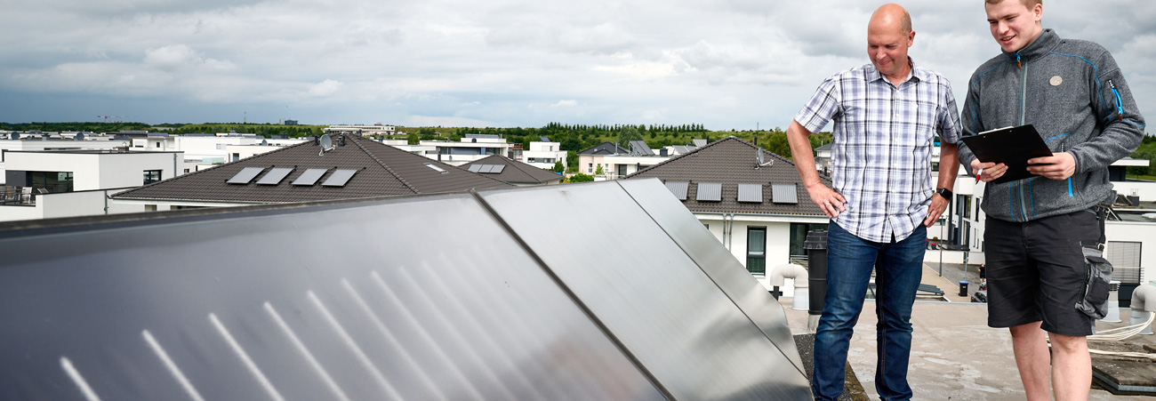 Eigentümer überprüft mit Monteur Photovoltaikanlage