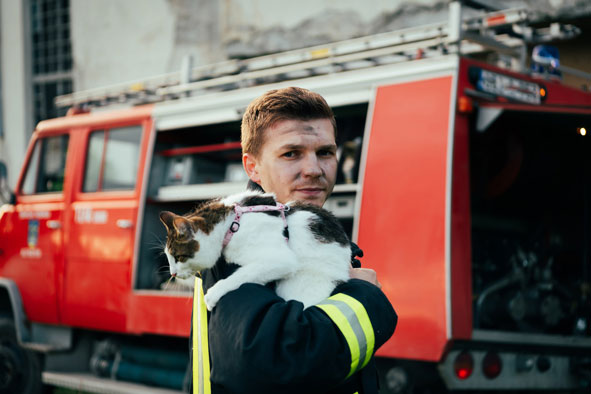 verußter Feuerwehrmann mit Katze