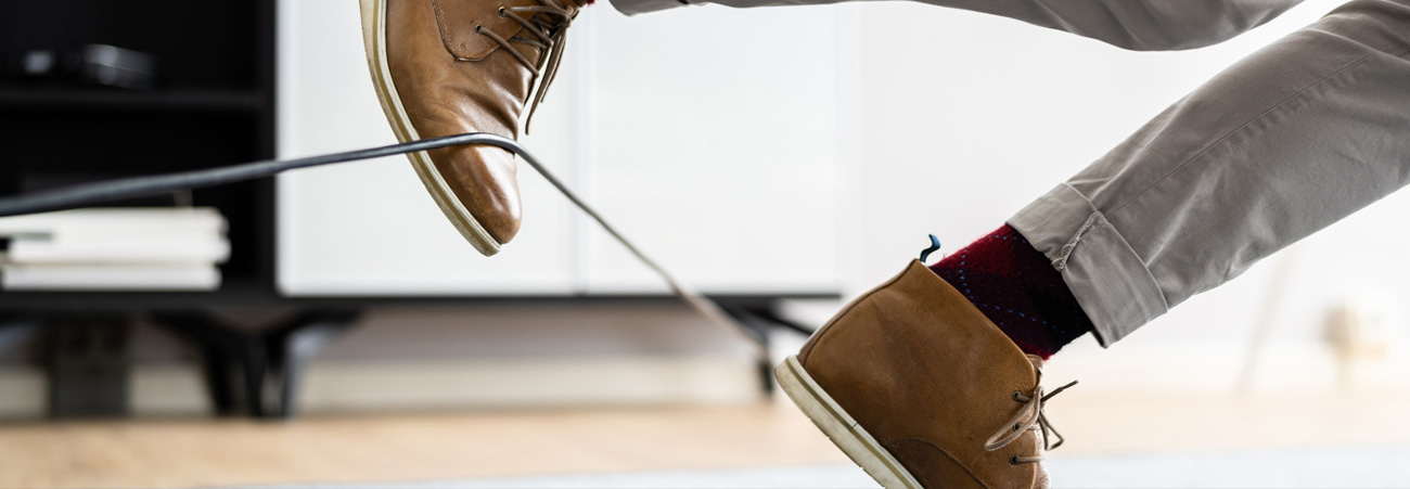 Mann stolpert über Kabel am Boden