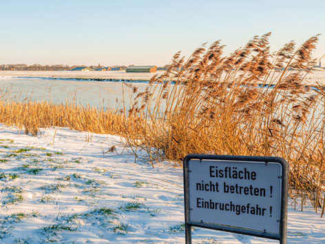 vereister See mit Warnschild nicht betreten