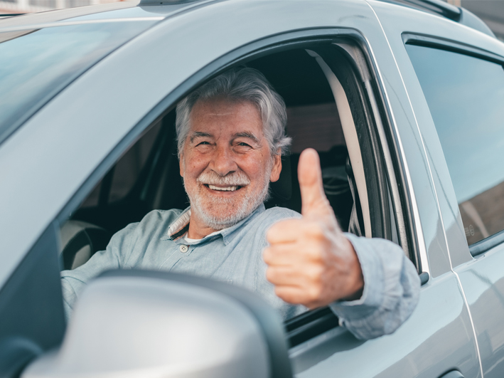 freundlicher Autofahrer mit Daumen hoch