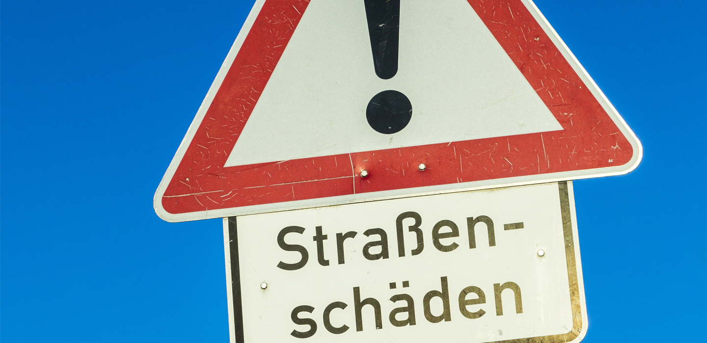 Warnschild Straßenschaeden