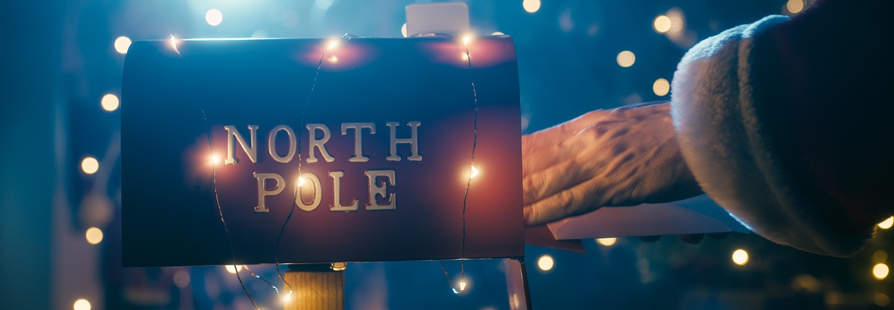 Weihnachtsmann holt Post aus dem Briefkasten am Nordpol.