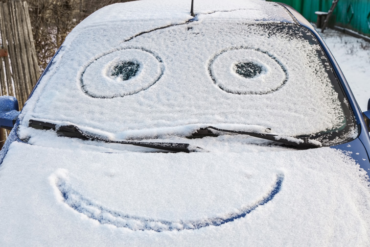 Schnee-Smiley auf Motorhaube Auto