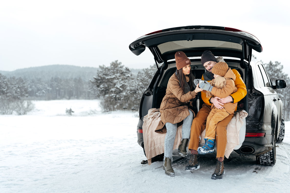 Familie Picknick im Auto im Winter