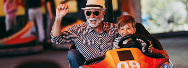 Cooler Opa fährt mit seinem Enkel Autoscooter