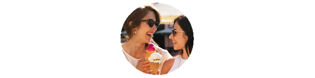 Zwei Frauen lachen und essen ein Eis.
