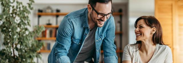 Mann und Frau lachen zusammen im Büro