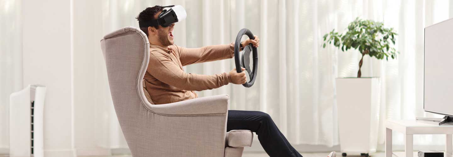 Mann fährt in Virtual Reality ein Auto.