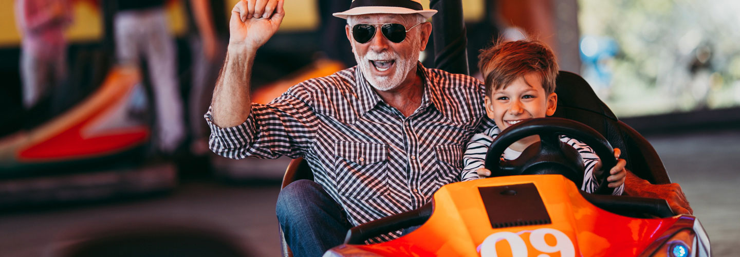 Opa und Enkel fahren Autoscooter.