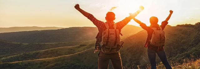 Paar genießt auf Berggipfel Sonnenaufgang