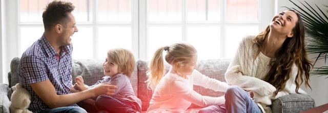 Lachendes Elternpaar hat Spaß mit seinen Kindern