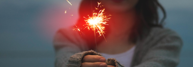 Junge Frau hält brennende Wunderkerze